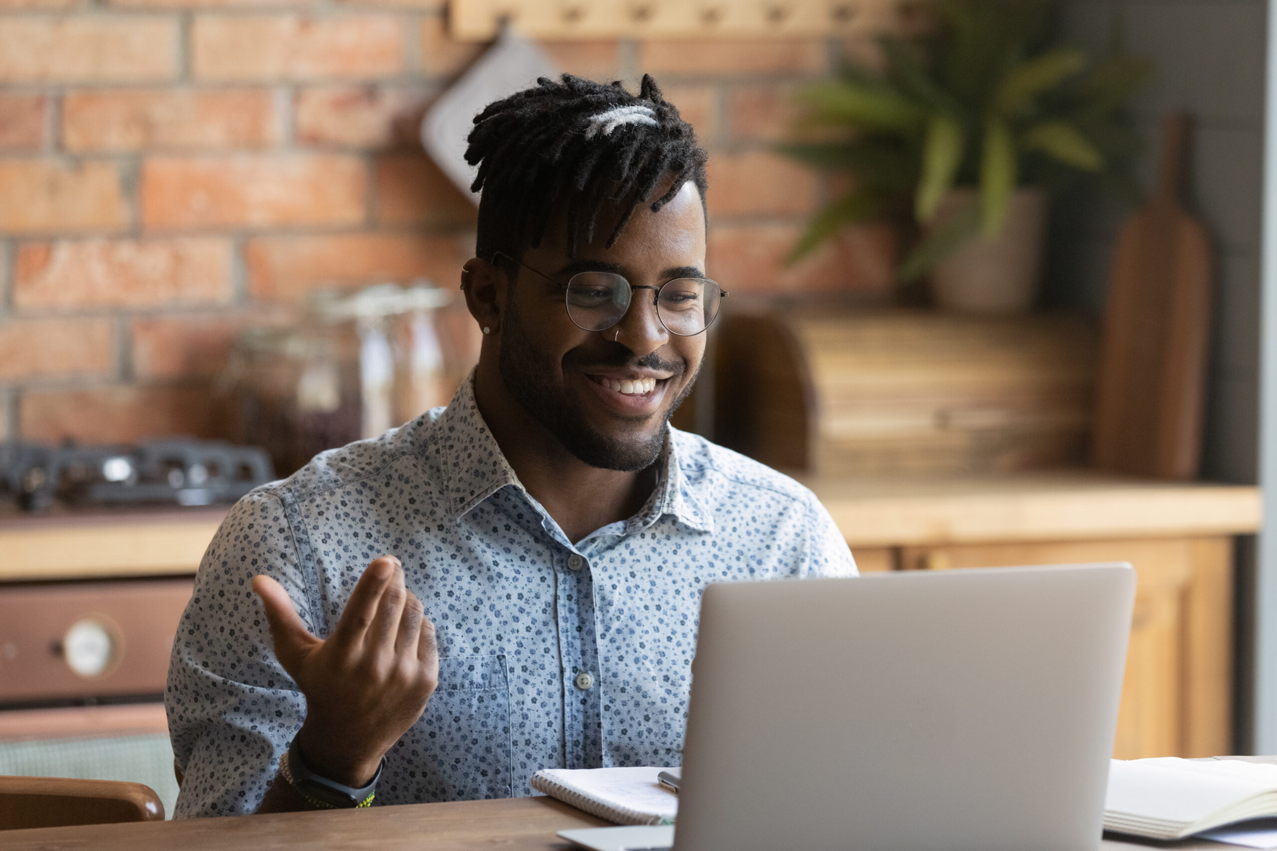 Man talking a smiling in front of a laptop.