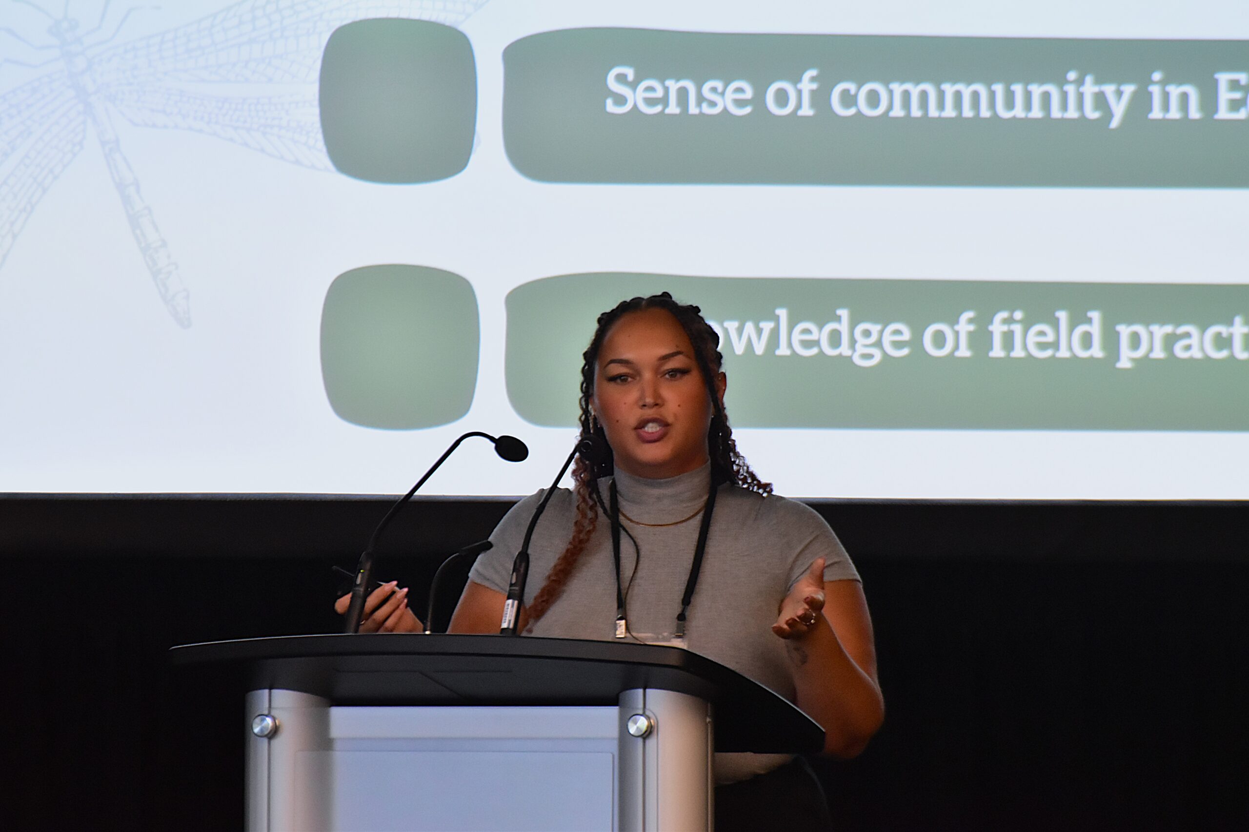 woman speaking into a microphone at the front of a room